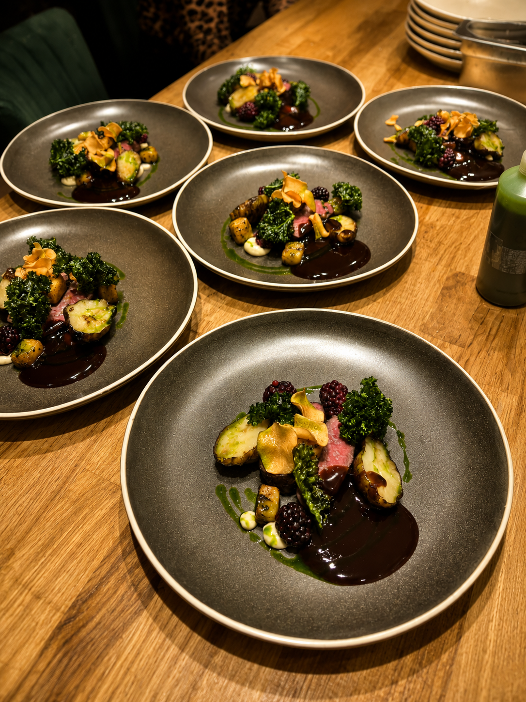 Plated beef course lined up for service