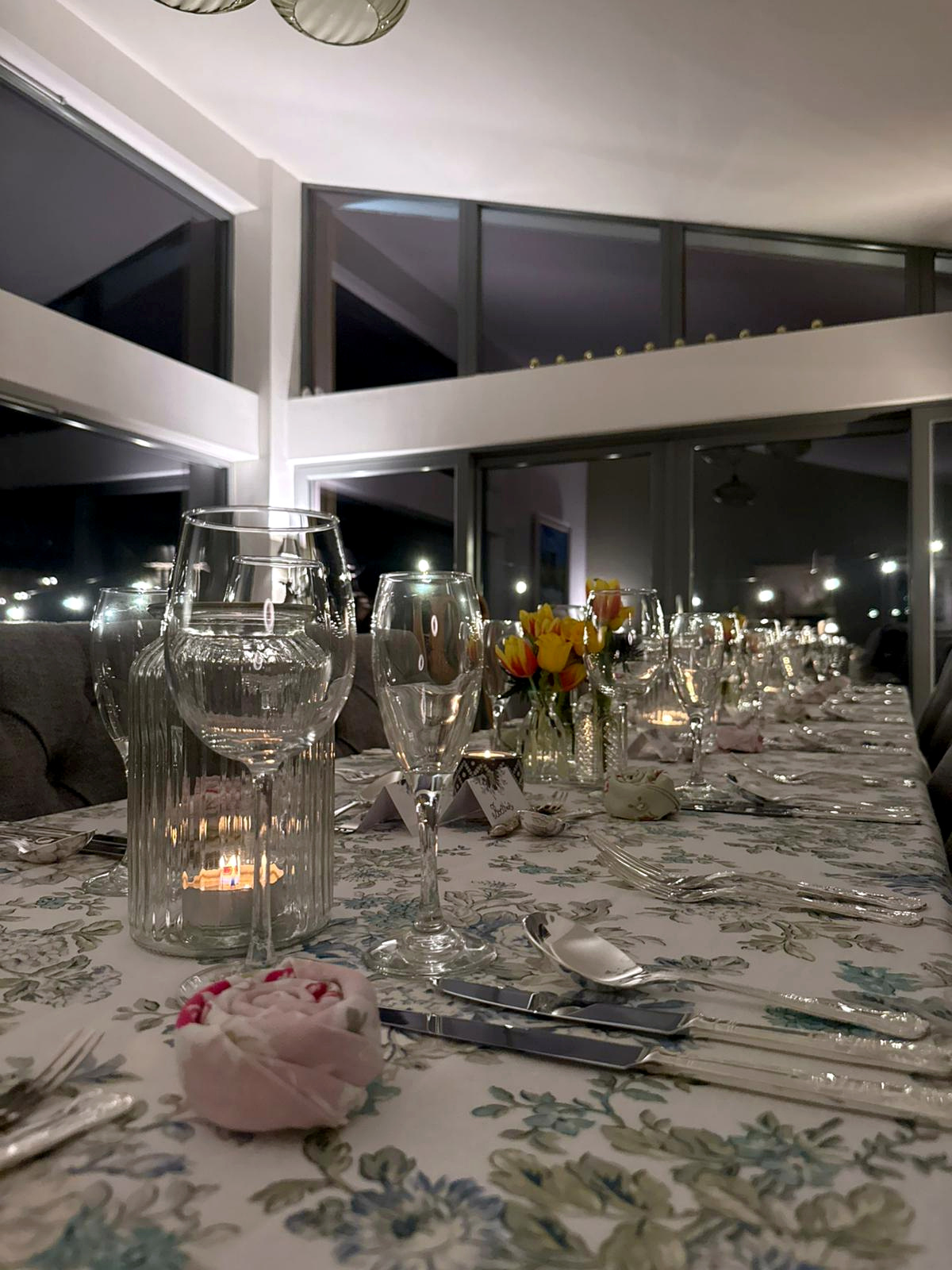 Candlelit dining table set with tulips and glassware
