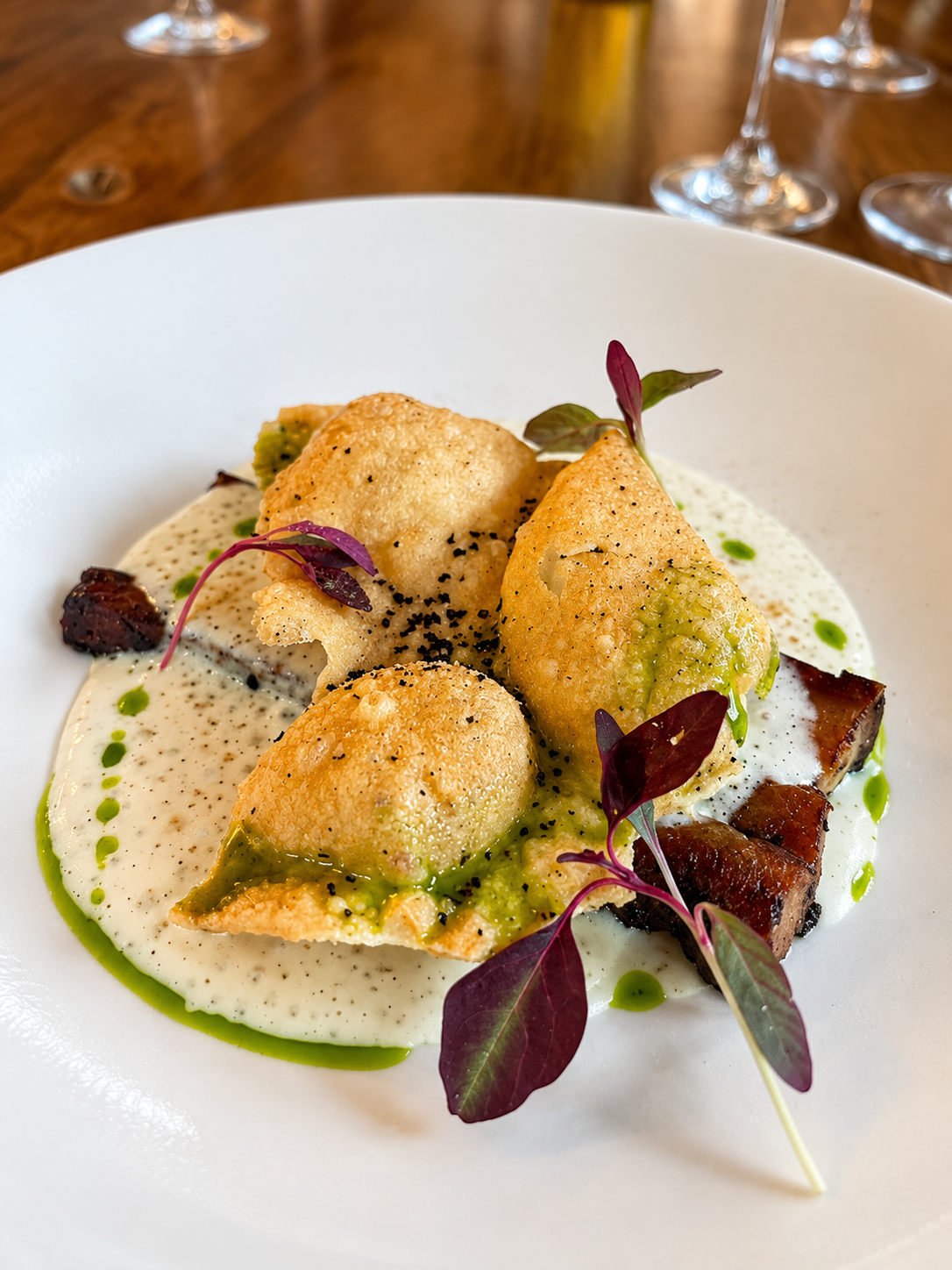 Crisp dumplings with herb oil, pork belly and microgreens