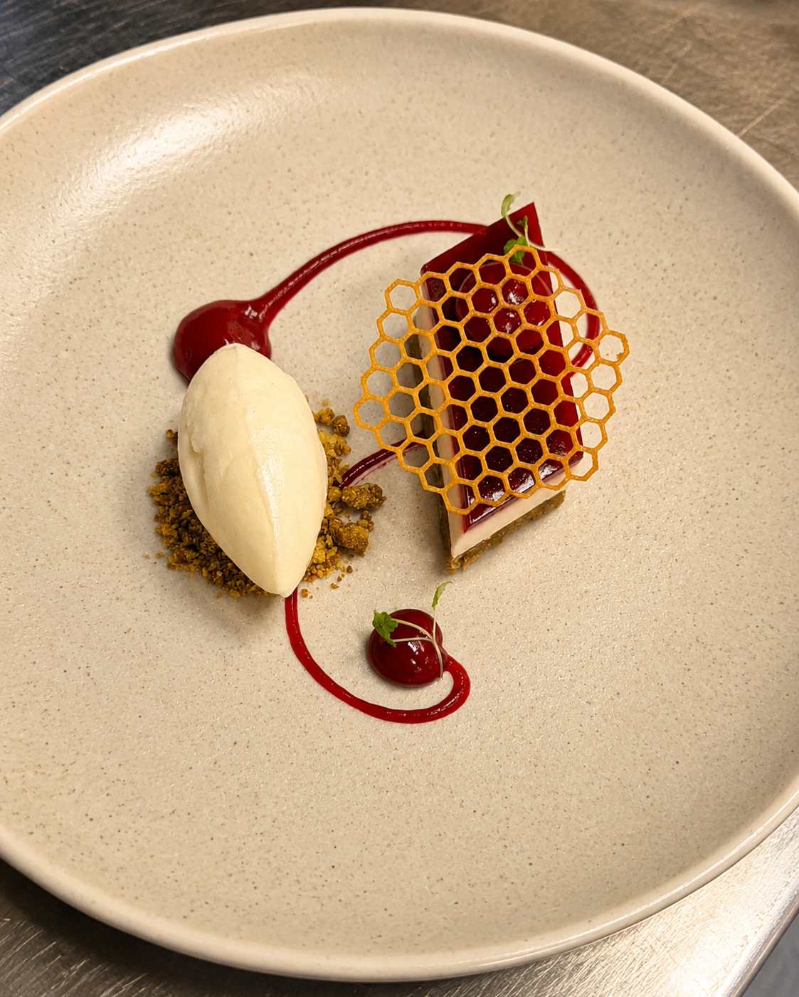 Honeycomb tuile dessert with sorbet and berry coulis